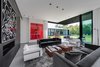 Large artwork hangs in the home's living room, which opens up to the backyard. Photo 2 of Ponce Davis Residence modern home