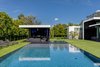 The backyard features an artificial lawn and a pool that comes right up to the grass' edge. Photo 11 of Ponce Davis Residence modern home