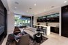Modern home with Living Room, Sofa, Chair, Recessed Lighting, Limestone Floor, and Ribbon Fireplace. A bar and lounge is found secluded on the right side of the home with access to the backyard and views of the water. Photo 8 of Palm Island Residence