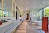 Modern home with Bath Room, Freestanding Tub, Wall Mount Sink, Marble Wall, Enclosed Shower, Recessed Lighting, Track Lighting, and Marble Counter. The master bathroom features separate his and hers vanities and showers. Photo 11 of Palm Island Residence
