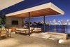 Modern home with Sectional, Recessed Lighting, Limestone Floor, Stone Tile Backsplashe, Wood Cabinet, Dining Room, Table, and Chair. The outdoor kitchen and lounge area are located underneath an immense canopy. Photo 9 of Casa Ischia