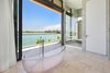 A custom-designed Ornare glass bathtub stands alone in the master bathroom. Photo 12 of Rivo Alto Residence modern home