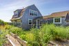 On the sunny south side of the existing rehabilitated 1880 structure, repurposed as a summer guesthouse, is a florishing garden which provides the owners with fresh vegetables, raspberries and blueberries. Photo of Corkin House modern home