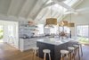 The kitchen/bar area, open to the dining/living area, consists of a large 5 foot wide by 12 foot long marble-topped island. At the back counter are granite-topped painted base cabinets and simple open shelving. Photo 7 of Corkin House modern home