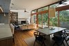 Modern home with Dining Room, Medium Hardwood Floor, Table, Stools, Chair, Track Lighting, Pendant Lighting, Desk, and Wood Burning Fireplace. View of Living/Dining/Kitchen Island Photo 7 of House on Little Round Bay