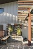 The sound of gurgling water softens the space. A concrete trough whose texture mimics coquina is a nod to the original coquina columns that were found on the site, explained Young. The fountain defines an edge of the courtyard, above it a vertical garden whose riot of succulents are contained by a custom Cor-Ten steel frame by Drew McGuckin of McGuckin Custom Metal Creations, who also brought several more of Young’s design ideas to life. Cast concrete planters blend with the porch, merging hardscape and landscape components into a singular moment. Photo 14 of 1600 Lakeside modern home