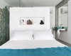 The white wall behind the bed divides the bath area from the bed area. The turquoise blue tiles on the shower and the basin were designed and produced by Maria Ulecia on her atelier and create the colour scheme for the bedroom Photo 10 of micasaenlisboa modern home