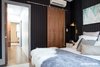 Master bedroom looking into hallway. Custom walnut sliding barn doors open up the spaces. Photo of East Harlem Residence modern home