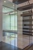 The glass wall allows light and views under the stairs, making the basement stairs inviting, and allowing for expansive sitelines. Photo 2 of Shadow on White Pallet modern home