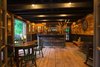 Oak was used for the floors and ceiling joists. Poplar was used on the wall to create the rich golden and brown tones. However, the poplar boards were tanned in the sun to create the gold coloring. Photo 3 of The Tavern modern home