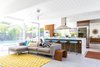 Modern home with Living Room, Stools, End Tables, Sectional, Pendant Lighting, Bar, and Rug Floor. For Urbanism Design's first project, interior designer Pamela Lin-Tam made the atrium the centerpiece of this Eichler. Here, the living area enticingly faces the swimming pool. Photo of Renovated Sunnyvale Eichler