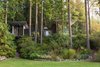 Modern home with Outdoor, Shrubs, Grass, Woodland, Trees, and Back Yard. In the 1980s, the retreat was made up of three tiny pavilions linked by wooden platforms. By 2003, the pavilions had been connected by a unifying roof, creating a single form grounded onto the hillside and projecting out over the landscape. Photo 2 of Cabin in Longbranch
