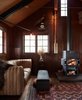 Modern home with Living Room, Bench, End Tables, Sofa, and Wood Burning Fireplace. Agate Pass Cabin | A cathedral ceiling was created by removing an attic floor. A 1970s Rais stove provides a heat source | The Rais 1, a Danish Modern wood stove by Bent Falk for Rais, circa 1974. This design represented a new form for the use of wood as a fuel source | 1970s sectional leather furniture by Ueli Berger, produced by De Sede in Switzerland | Artwork: 'Sapling' by an anonymous artist. The wood layers of a 4 x 10 wood beam were peeled away to reveal the original sapling—the life of the tree, in reverse. Photo 7 of Agate Pass Cabin