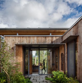 A view of the front door leading to the centrally located living spaces. Clerestory windows above maximize access to natural light while still preserving plenty of privacy.