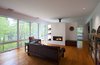 Modern home with Living Room, Medium Hardwood Floor, Sofa, Ceiling Lighting, Wood Burning Fireplace, Chair, and Ribbon Fireplace. Frontenac House - Great Room Photo 6 of Frontenac House