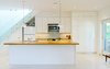 Modern home with Light Hardwood Floor, Ceiling Lighting, Wood Counter, White Cabinet, Pendant Lighting, Drop In Sink, Microwave, Dishwasher, Staircase, and Glass Railing. Our House - Kitchen Photo 12 of Our House