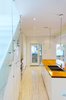 Modern home with Wood Counter, Drop In Sink, White Cabinet, Light Hardwood Floor, Ceiling Lighting, Pendant Lighting, Staircase, and Glass Railing. Our House - Kitchen Photo 11 of Our House