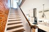 Modern home with Stone Counter, White Cabinet, Pendant Lighting, Ceiling Lighting, Accent Lighting, Range Hood, Cooktops, Staircase, Wood Tread, and Wood Railing. Bickford Park - Stairs Photo 9 of Bickford Park
