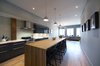 Modern home with Engineered Quartz Counter, Wood Counter, Light Hardwood Floor, Pendant Lighting, Ceiling Lighting, Range Hood, Cooktops, Dining Room, Range, Stools, and Bar. Elgin Loft - Kitchen Photo 10 of Elgin Loft