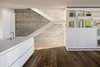 The staircase goes through the center of the house, pictured here adjacent to the open plan kitchen/living area. Photo 7 of The Dual House modern home