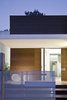 A dramatic front entrance comprised of horizontal wooden slats and a cantilevered canopy. Photo 11 of eHouse modern home
