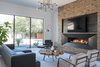 Metal and brick fireplace with cement balls. Eames chair and cut root wood coffee table. Italian leather sofa and cut velvet chairs from Cantoni. Photo 5 of Industrial Modern Home built by husband and wife team modern home