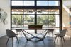 Wall of windows in this modern dining room. Walnut and iron table with walnut buffet. Photo 7 of Industrial Modern Home built by husband and wife team modern home