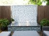 A custom firepit with glass tile, stainless steel counter and stacked stone bring the focus to this patio area. Photo of Outdoor Living modern home