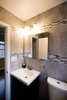 The bathroom was updated with modern finishes, while tile was used in a unique banding stripe to provide interest while saving money. Photo 8 of Asian Bungalow - Garden Apartment modern home