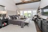 Master bedroom with high vaulted ceilings with exposed wood beams and private balcony Photo 20 of Modified Amelia II Model by DJK Homes modern home