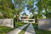 A board formed concrete wall provides a threshold at the arrival and frames a view of the house Photo 16 of Boetger Residence modern home