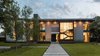 Modern home with Exterior, House Building Type, Metal Siding Material, Stone Siding Material, Flat RoofLine, and Concrete Siding Material. Taula House by M Gooden Design | Exterior // Approach Photo of Taula House