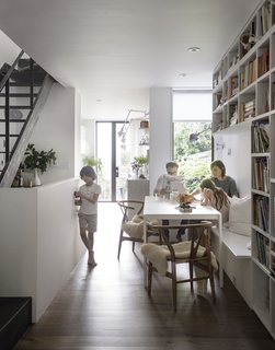 The first floor is a continuous public space featuring a dining area, kitchen, and living room.