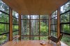 The feeling of being enveloped in the forest is heightened by windows that extend a couple of inches above the slightly dropped hemlock ceiling. This space was originally going to contain the master bedroom until the Owner realized that the view—and the feeling of being in a treehouse—was too magical to waste on a room used for sleeping. Photo 8 of Lightbox modern home