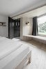 Modern home with Bedroom, Bench, Shelves, Wall Lighting, Light Hardwood Floor, and Bed. The lamps used in guest rooms are handcrafted in pure copper, while the curtains are produced in a local loden factory (loden, from the old German word "lodo" meaning "wool bale," is a woolen fabric produced in the region since the Middle Ages), thus reflecting a strong regional connection to the hotel and its locale. Photo 8 of Hotel Bühelwirt