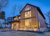 Barn rail system with moveable shutters which provide cover for large south facing windows. Elegant pine cone shaped lighting creates art and glow. Photo of Modern Barn Revival modern home