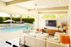 Modern home with Living Room, Table Lighting, Floor Lighting, Sectional, End Tables, Chair, Pendant Lighting, Sofa, Track Lighting, Bench, and Ceramic Tile Floor. Living Room Photo of Waters Edge. Private Meiselman Mid-Century Modern with Views and Stunning Saltwater Pool