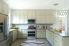 Modern home with Kitchen, Wood Cabinet, Ceramic Tile Backsplashe, Engineered Quartz Counter, Ceiling Lighting, Concrete Floor, Pendant Lighting, Microwave, Dishwasher, Refrigerator, Range, and Undermount Sink. Kitchen / Open Floor Plan Photo 6 of East 9th House