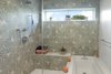 Modern home with Bath Room, Engineered Quartz Counter, Ceramic Tile Floor, Drop In Tub, Undermount Sink, Enclosed Shower, Concrete Wall, Full Shower, and Ceiling Lighting. Master Bathroom Photo 5 of East 9th House