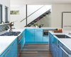 Modern home with Kitchen, Engineered Quartz Counter, Ceiling Lighting, Medium Hardwood Floor, Colorful Cabinet, Range, Glass Tile Backsplashe, and Undermount Sink. Kitchen - Open Floor Plan Photo 5 of Norris House