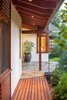 The entry displays a diversity of wood species: Mahogany panels at the wall, a Cedar slat walkway and Douglas Fir framing members. A copper rain chain diverts rain water to the entry planting bed. Photo 3 of Lakeside House modern home