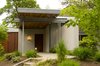 A Mahogany wood soffit cantilevers over the home's entry. Photo of Cedar Mills House modern home
