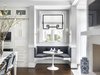 Modern home with Dining Room. Designed by Mitchell Wall Architecture & Design, this Hamptons home embodies a sense of laidback luxe with timeless design and thoughtful finishes. Within the hub of the home lies the kitchen, which incorporates a midnight blue and white color palette accented by warm brass hardware. Tucked away near the fireplace, a banquette with floating seats offers a quiet, out-of-the-way place to sip a coffee. Photo 6 of Hampton's House