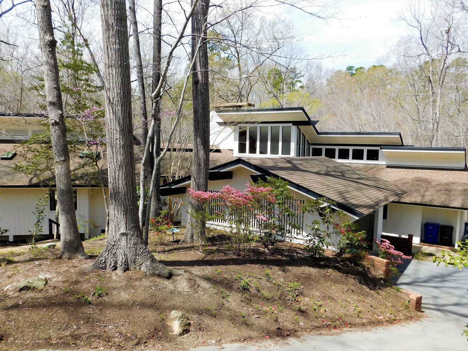 New white paint with black trim helps the original beam and roof design shine bright from the front of the home.