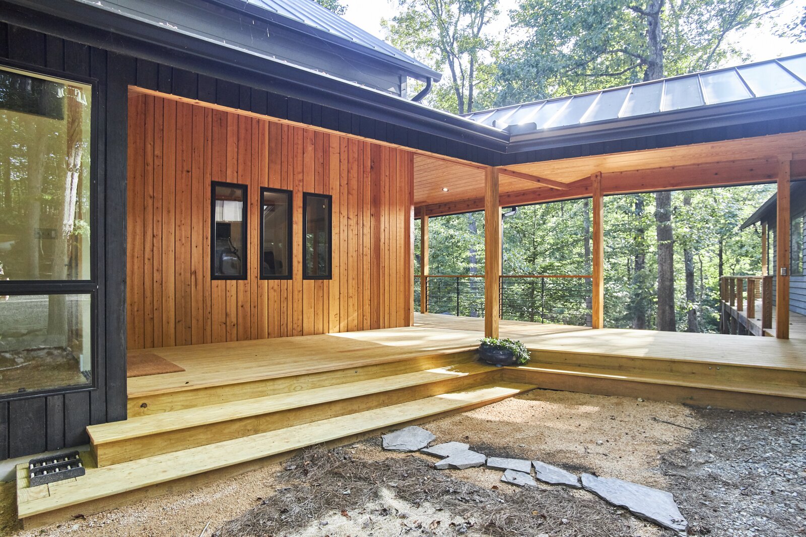 Wraparound covered porch with tongue and groove pine ceiling and cedar beam wrap and trim.