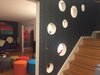 The bubble circles in the wall between living room and stair case bring in natural sun light to the stair case. Photo 9 of The Bubbles House modern home