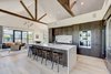 Modern home with Kitchen, Engineered Quartz Counter, Wood Cabinet, Light Hardwood Floor, Recessed Lighting, Ceiling Lighting, Refrigerator, Marble Backsplashe, Wall Oven, Wine Cooler, Microwave, Dishwasher, Ice Maker, and Drop In Sink. Walnut cabinetry under hand sawed beams. Photo of Jagger Lane