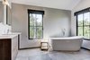 Modern home with Bath Room, Engineered Quartz Counter, Ceramic Tile Floor, Wall Mount Sink, Soaking Tub, Ceiling Lighting, Full Shower, Recessed Lighting, and One Piece Toilet. Master bathroom with large soaking tub. Photo 7 of Jagger Lane