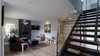 We bumped out the entry to create a more comfortable progression from outside to in, broke down the wall to the stair, and stacked the new stair to the stair directly above it. Photo of Eave House modern home
