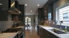 Keeping and eye on costs - the kitchen remained in the original location, but was updated to fit the new aesthetic. The kitchen maintains a visual connection to backyard through the adjacent dining room. Photo 6 of Eave House modern home